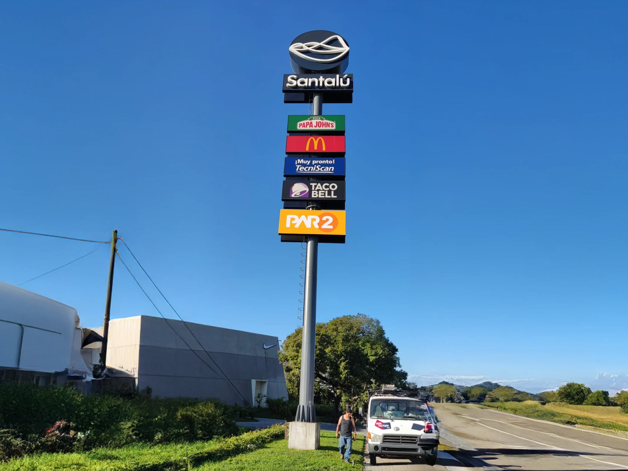 Tótem exterior de Santalú con logos de Papa John's, McDonald's, Tecniscan, Taco Bell y Par 2.