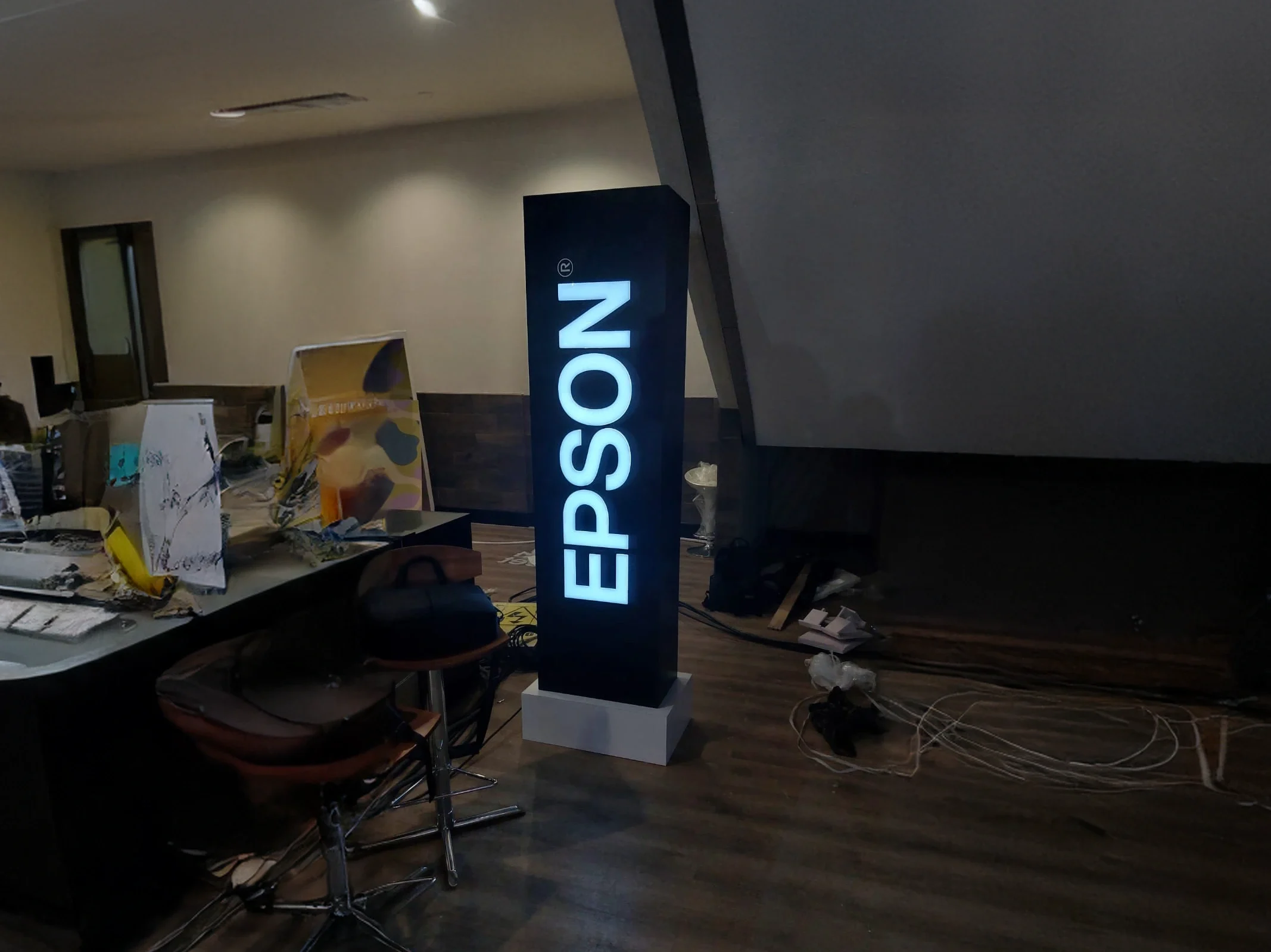 Tótem negro de Epson con base blanca e iluminación.