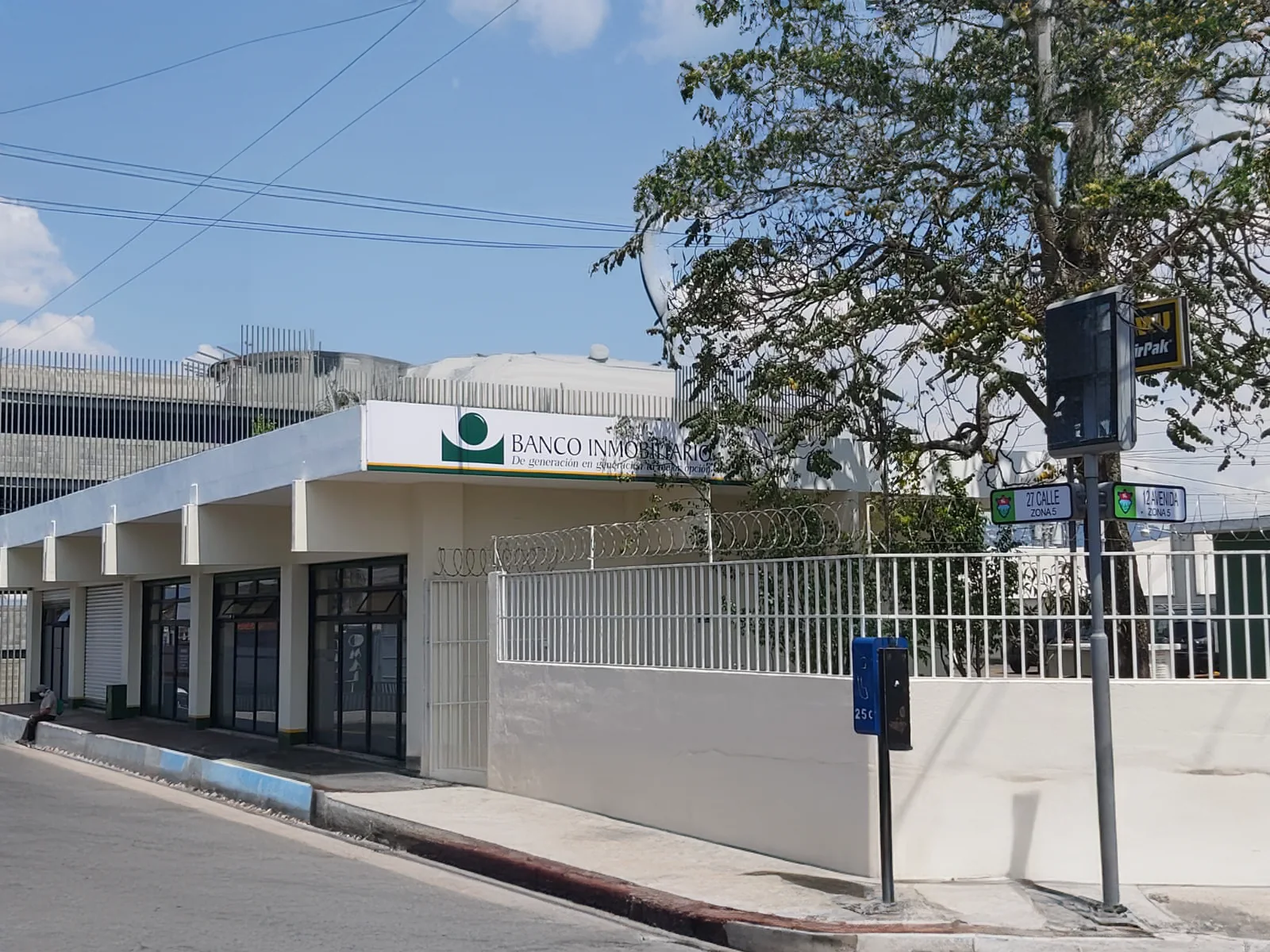 Fachada con paredes blancas y nombre del banco