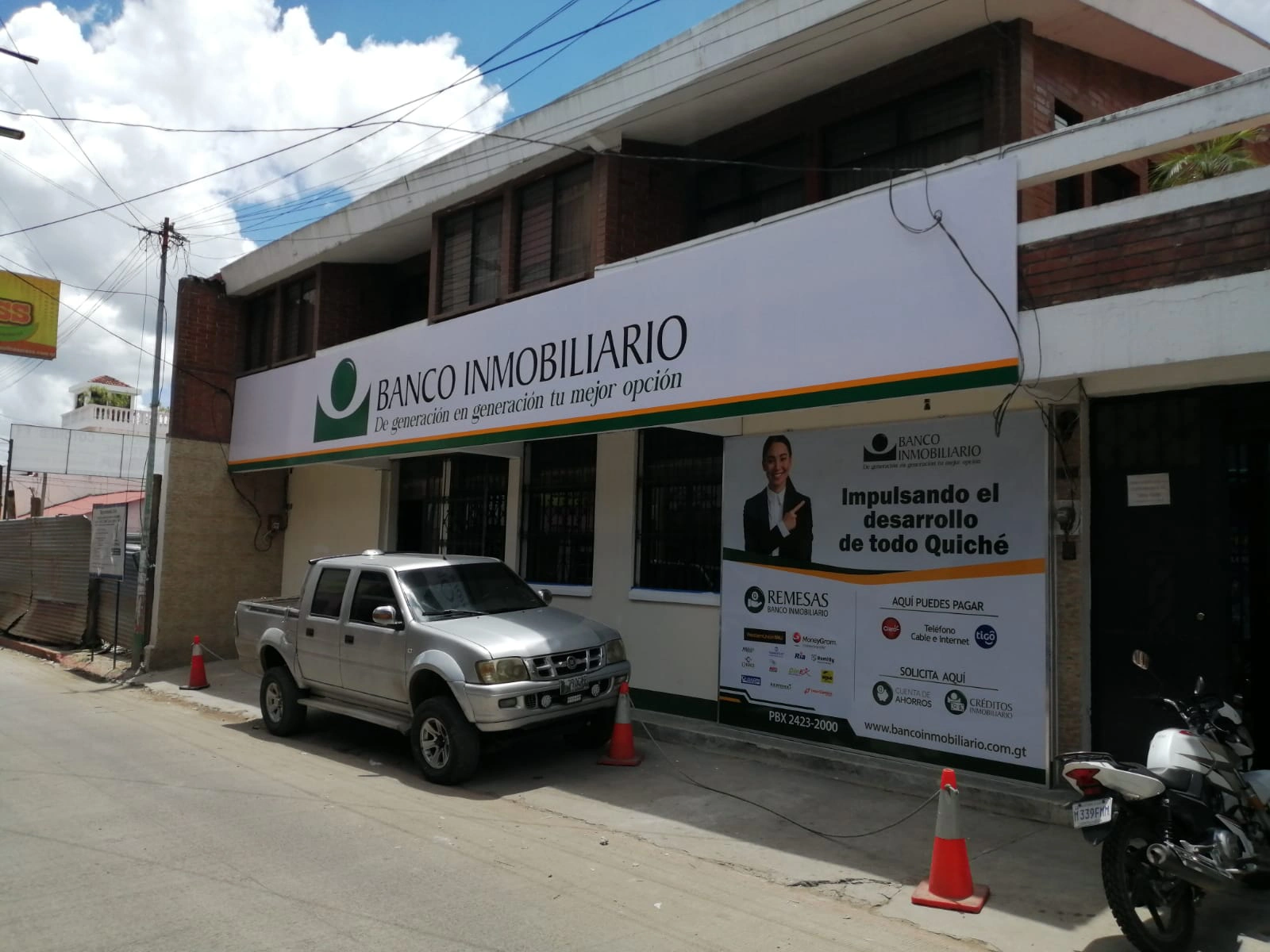 Fachada para Banco Inmobiliario con eslogan y logo desde otra perspectiva