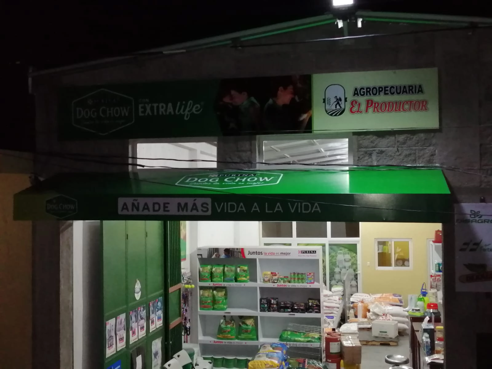 Fachada y cenefa verde con logo de Purina y eslogan desde otra perspectiva