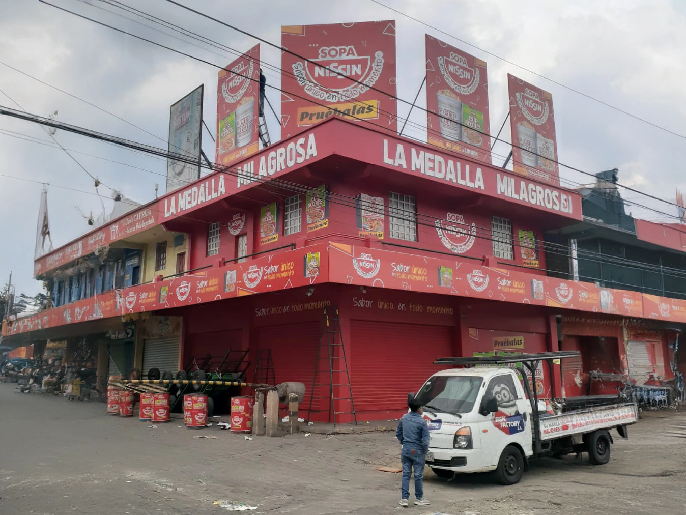 Fachada roja y blanca con logos de sopa nissin y Cup Noodles