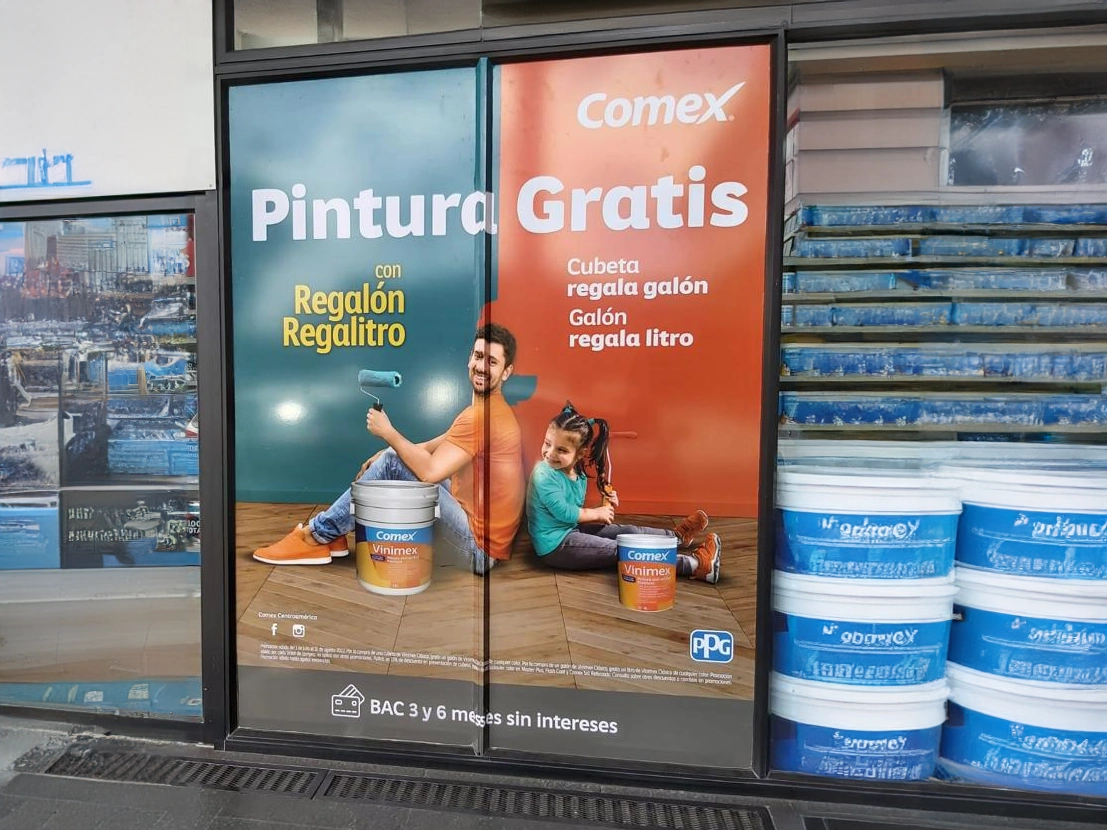 Mural de Comex en puerta automática con promoción de pintura gratis