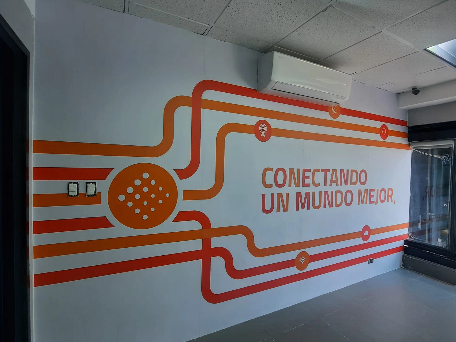 Mural de COMNET con frase "Conectando un mundo mejor"