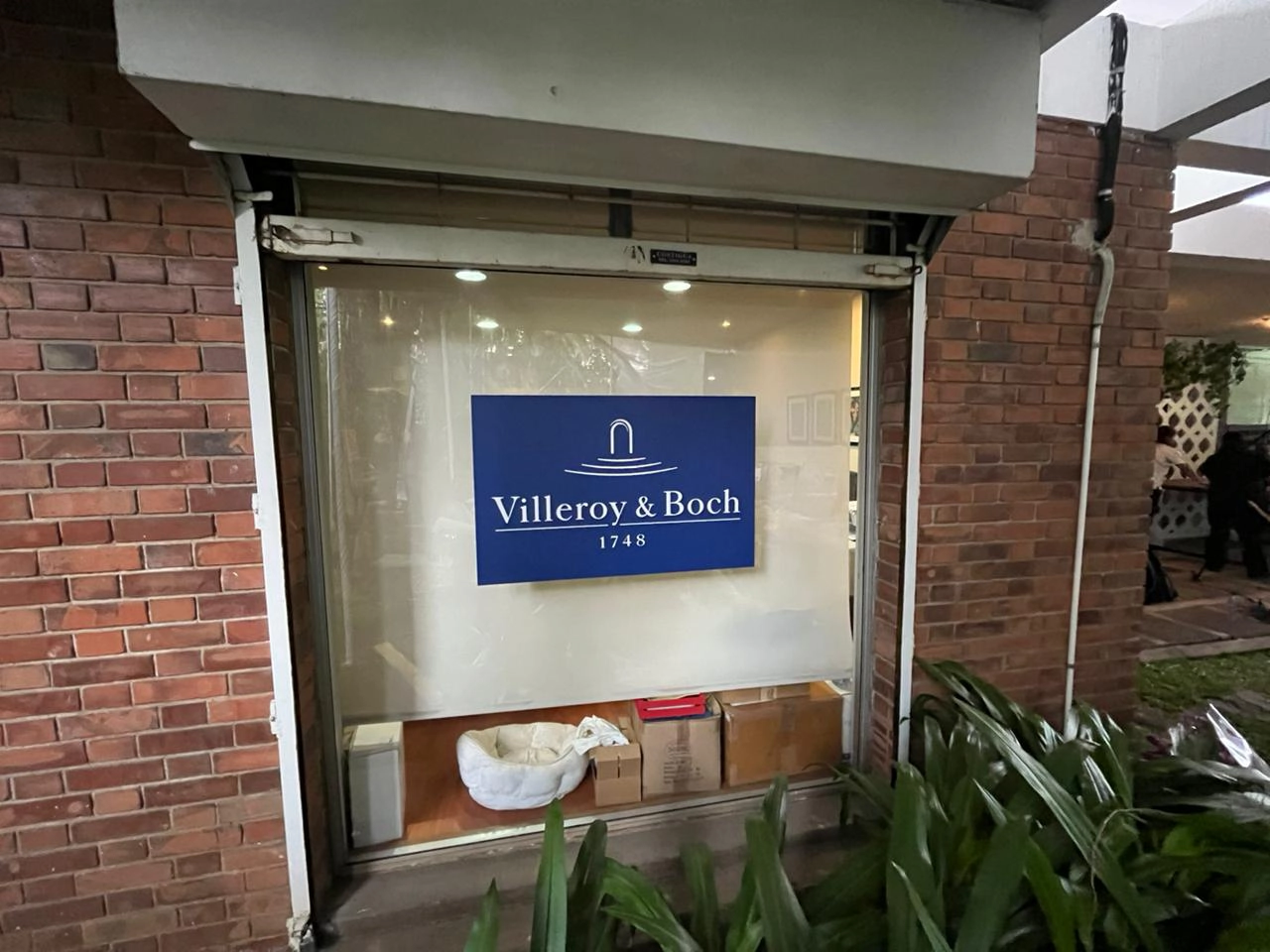 Sticker azul con logo blanco de Villeroy & Boch en vitrina